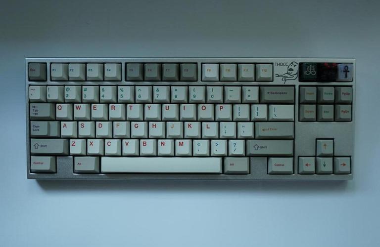 Thocc Kay El (IC) - Keyboard interest check cover image featuring keyboard, community, anime-inspired, CNC-machined, PVD brass, Massdrop, retro-futuristic, aluminum, brass weight, solder PCB, 40% kits
