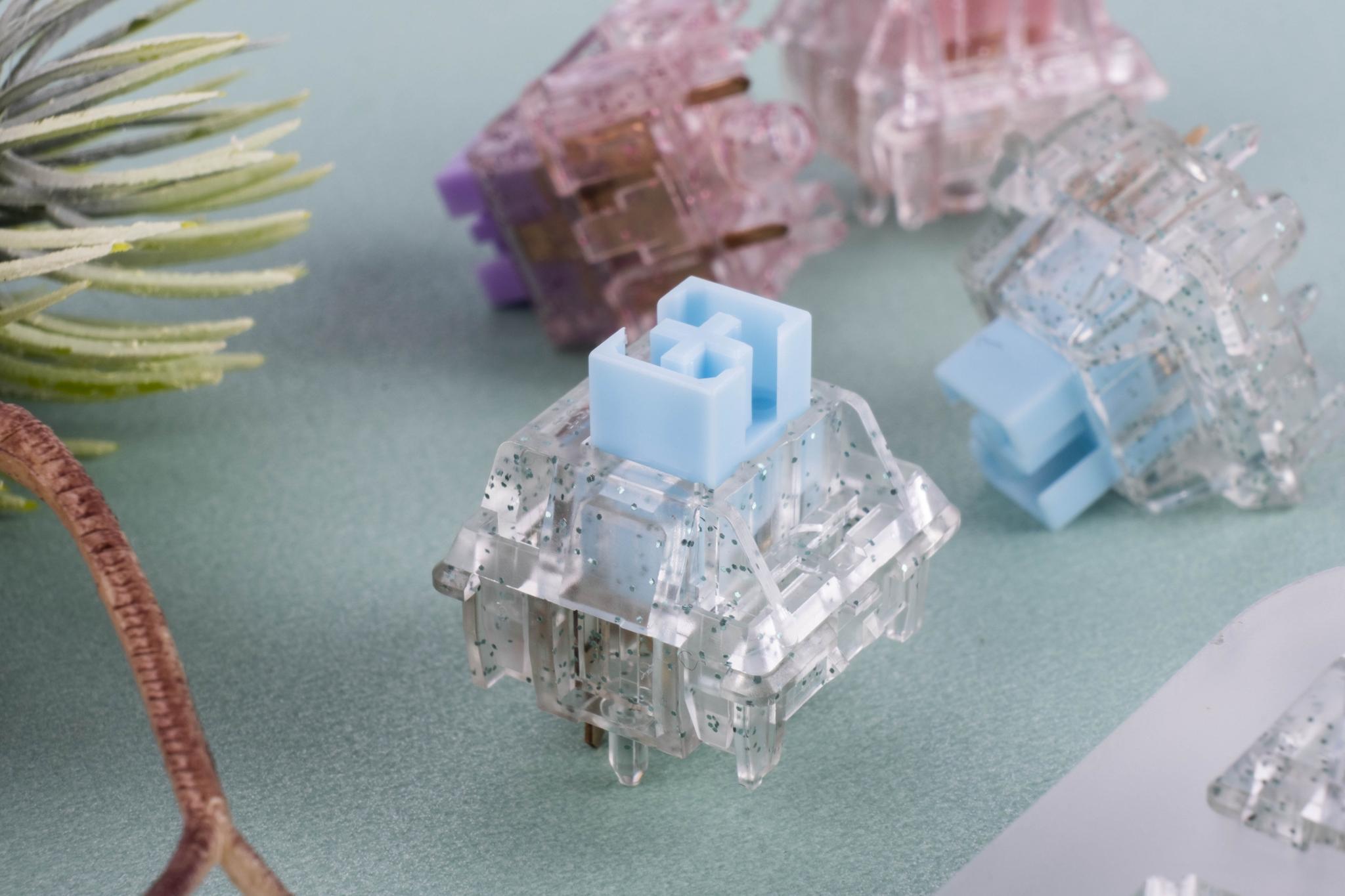 Velocifire X Bling Switch (IC) - Switch interest check cover image featuring Bling Switch, keyboard switch, Velocifire, Keyfirst, HM, Kailh engineer, shiny powder, transparent housing, POM Stem, Gold Plated Spring